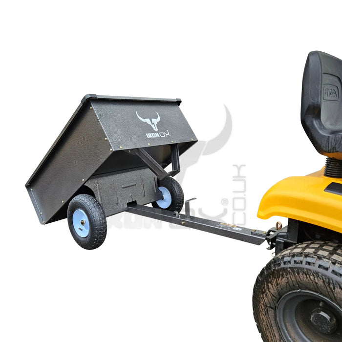 A yellow tractor with an Iron Ox® 'MT' - Tipping Trailer 400lb attached to it.