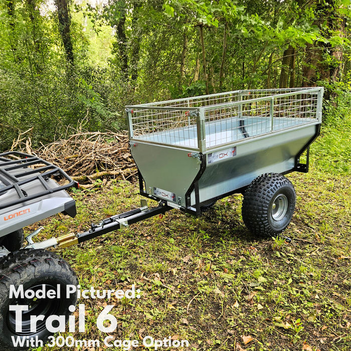 An All-Terrain ATV & Farm Tipping Trailer | Heavy-Duty Utility Trailer - Trail 6 with a 300mm mesh cage is attached to an ATV, parked on grass in a wooded area surrounded by branches.