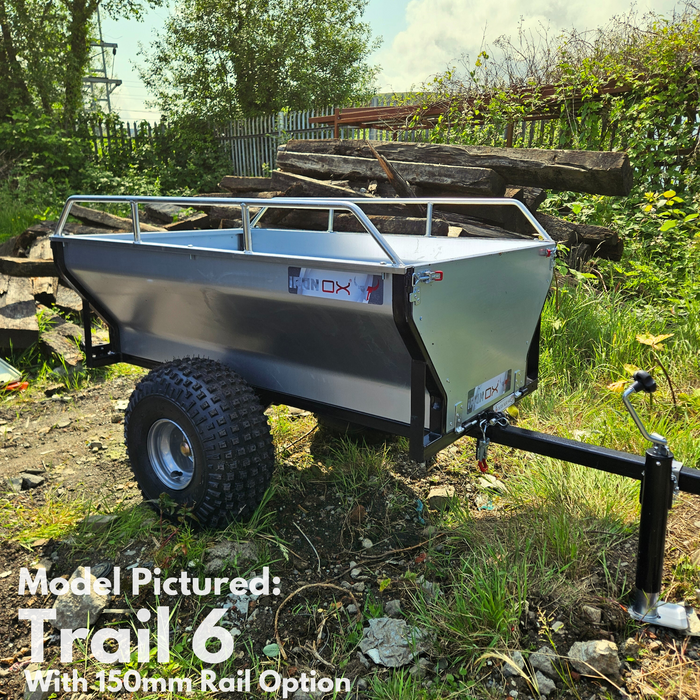 Steel ATV trailer with tipping bed loaded with firewood in rural UK setting