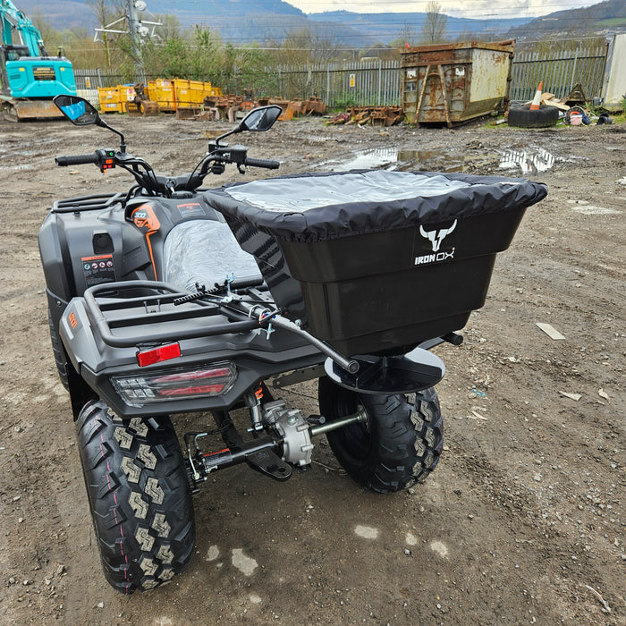 New ATV Quad Bike Seed Feed Fertiliser Spreader 12V parked on a gravel surface with construction equipment in the background.