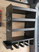 The Van Racking Drill & Accessory Shelf for Garages and Workshops is a black metal storage unit that mounts on the wall and features shelves, hooks, and compartments for efficient organization of power tools in your garage.