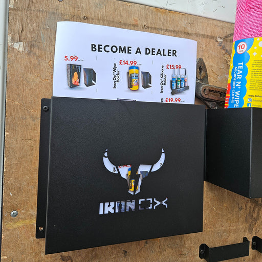 A black File & Paperwork Holder with the "iring xx" logo and a bull's head design, wall-mounted on a wooden surface beside various flyers and advertisements.