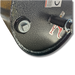Close-up view of the heavy-duty textured black metal surface of the Lawn Roller 60", featuring a bolt and a protruding cylindrical component with small labels marked in red. The design implies universal hitch compatibility, making it perfect for rugged tasks like lawn care.