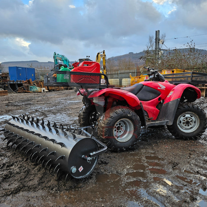 A red ATV with a Towable Spiked Roller Aerator 60" Wide in the mud.