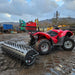 A red ATV with a Towable Spiked Roller Aerator 60" Wide in the mud.