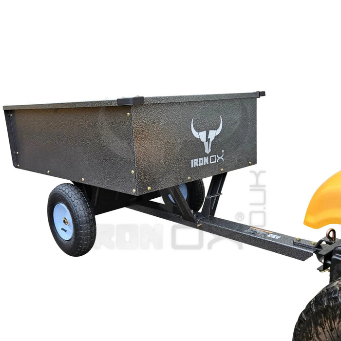 An Iron Ox® 'MT' - Tipping Trailer 400lb attached to an ATV for transporting goods.