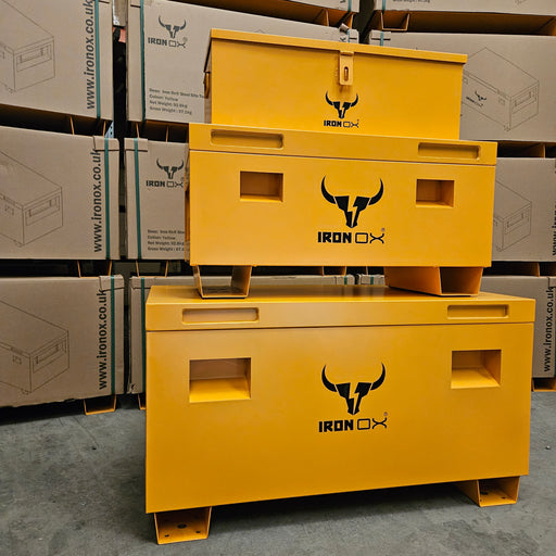 Two yellow IronOx Contractors Van & Site Tool Chest Boxes, 45", are stacked in a warehouse amid IronOx-branded cardboard boxes, providing anti-theft protection for valuable equipment.