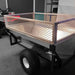 A trailer with a metal basket on it, featuring Titan 5.0 Side Extenders 12" for added height and a sleek powder coated silver finish.